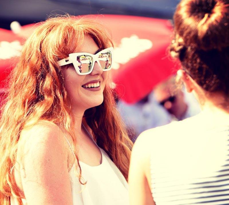 Woman wears white sunglasses in the sun