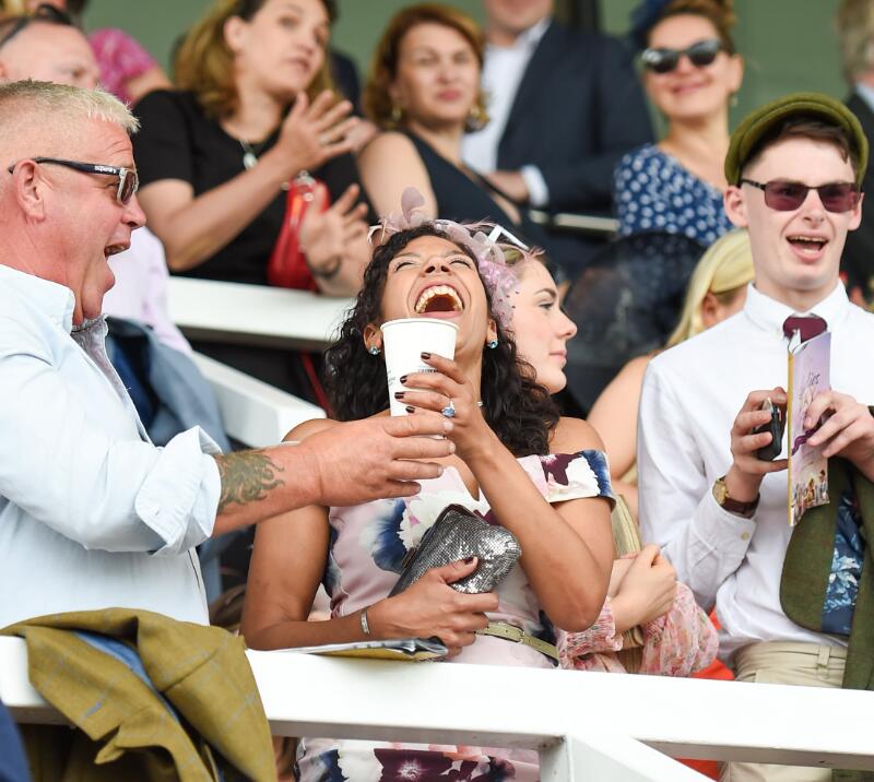 A couple laughing and joking in the stands at Uttoxeter Racecourse