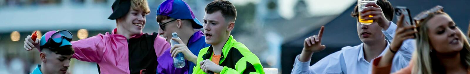 A group of guys dressed up as jockeys enjoying the music at Uttoxeter Races