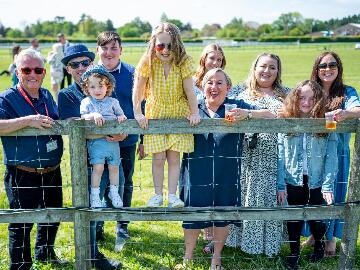 A family enjoying the races in the sunshine.
