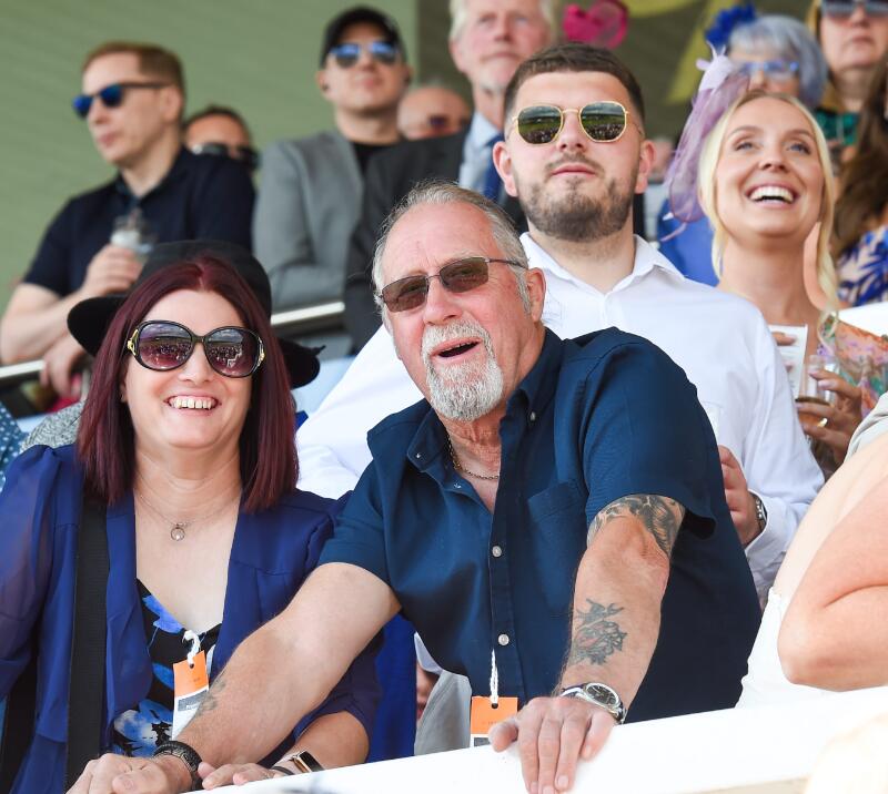 A group of race goers watching from the stands at Uttoxeter