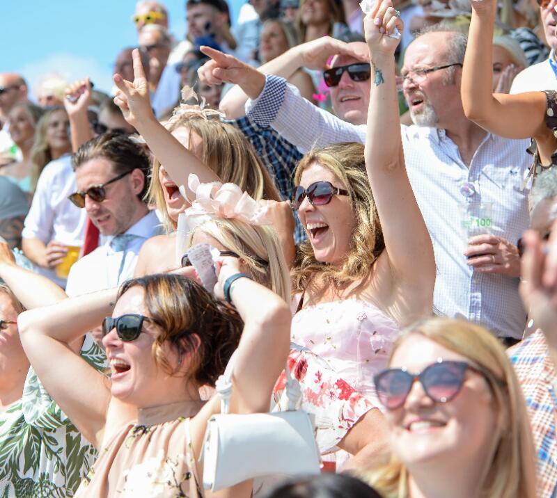A close up of some of the crowd at Uttoxeter Races celebrating wildly