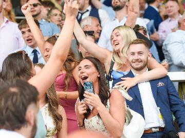 A group of friends in the grandstands at Uttoxeter Racecourse celebrating the races